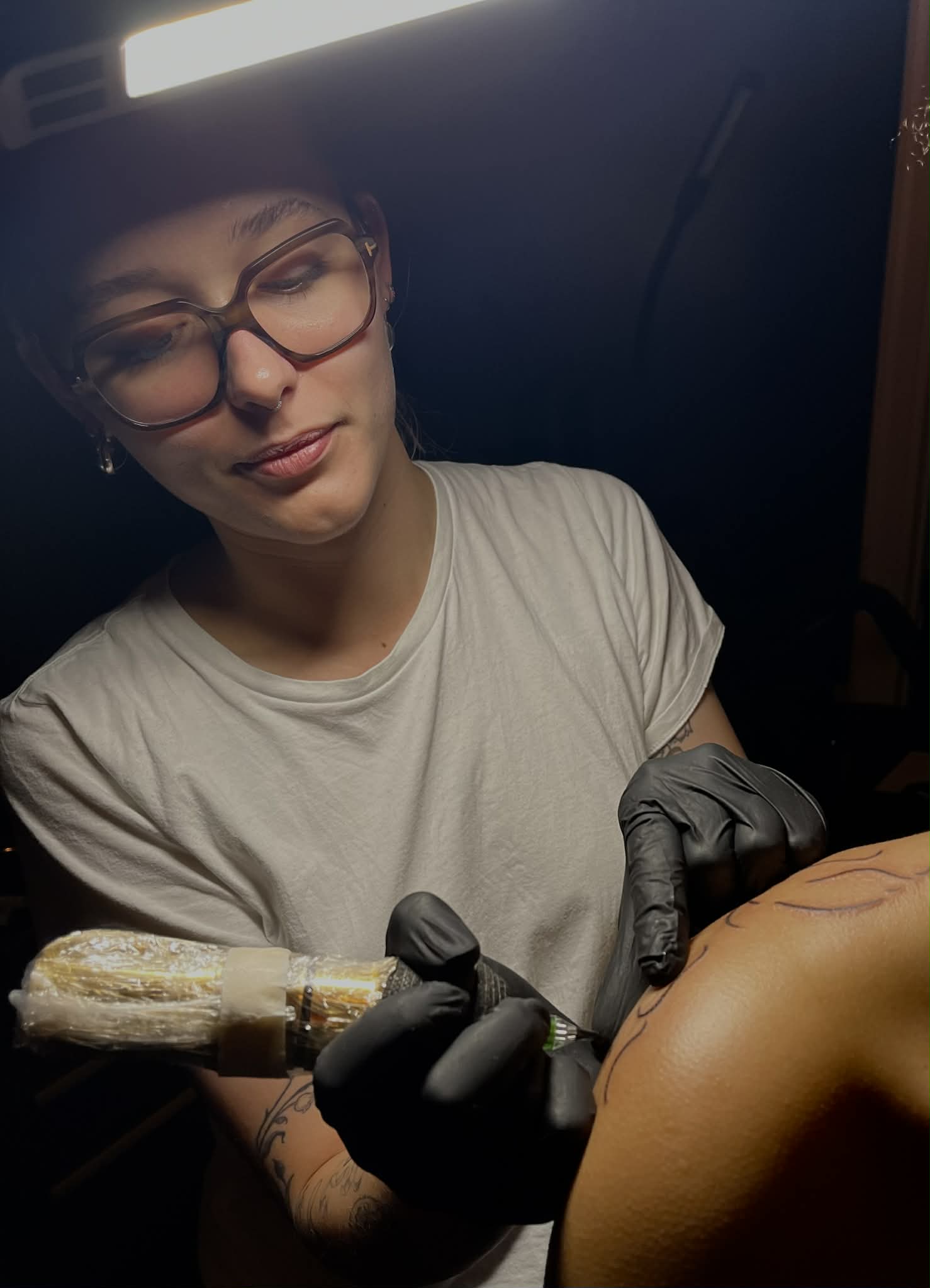 Tatovør arbejder på skuldertattoo under lampe