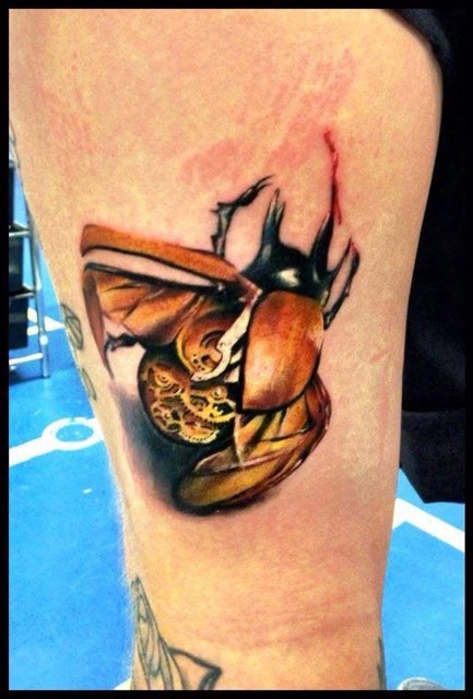 Farverig tatovering af mekanisk bille på hud