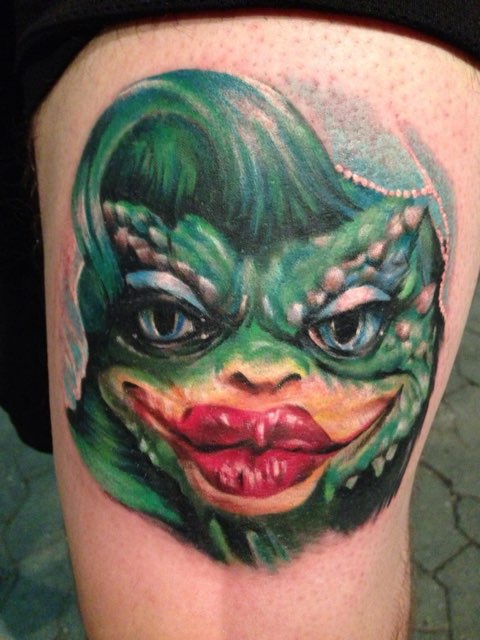 Farverig tatovering af grøn monsteransigt
