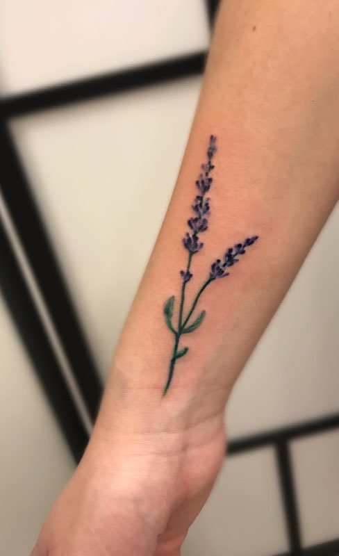 Lille lavendeltatovering på underarm