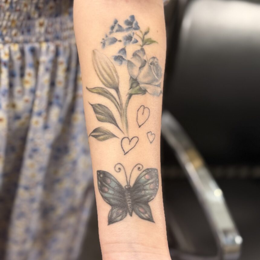 Underarm med blomster- og sommerfugletatovering