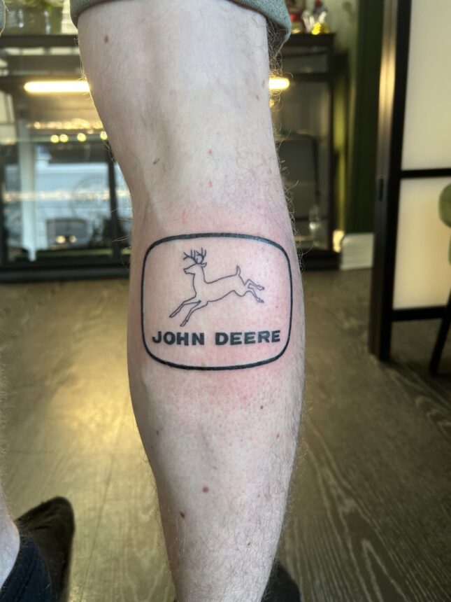 Tatovering med John Deere-logo på læg