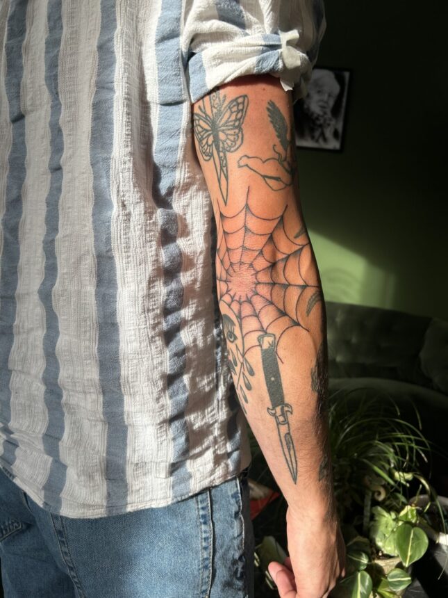 Arm med tatoveringer i sollys indendørs